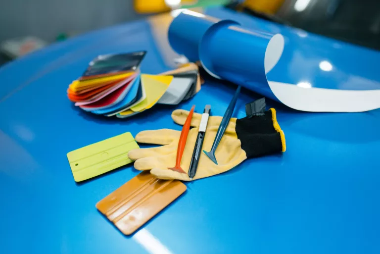 Fahrzeugbeschriftung 2 autoverpackung vinylschutzfolie oder filmfarbpalette und installationswerkzeuge auf der fahrzeugnahaufnahme auto detaillierung